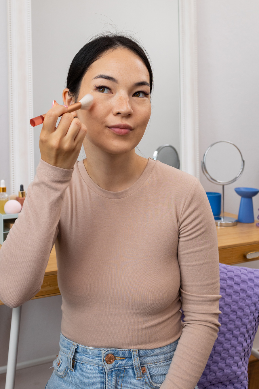 Woman Applying Makeup on Face with a Brush